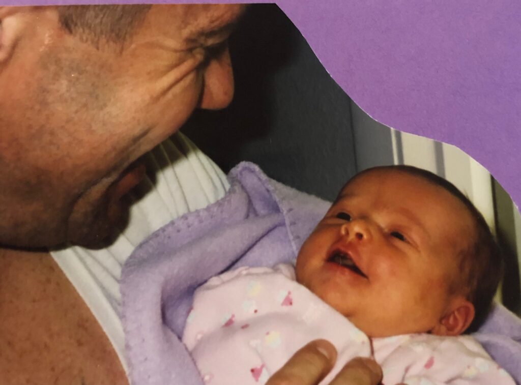 A close up of a man smiling at a baby who's smiling back