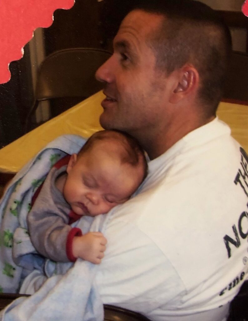 a man holding a baby who's sleeping on his shoulder