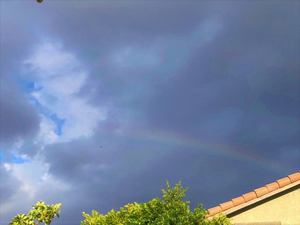 a faint rainbow and dark clouds