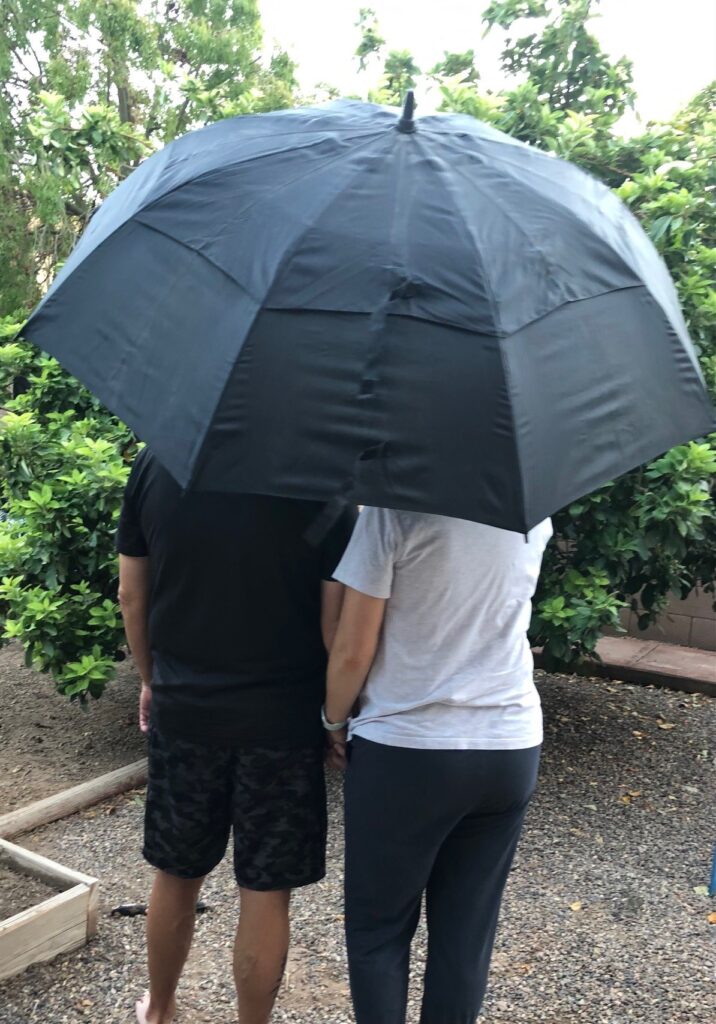 two people close together under a black umbrella