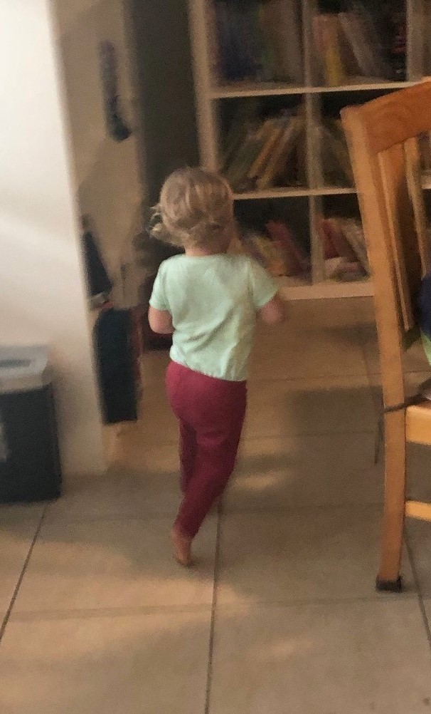 a toddler girl running from the camera