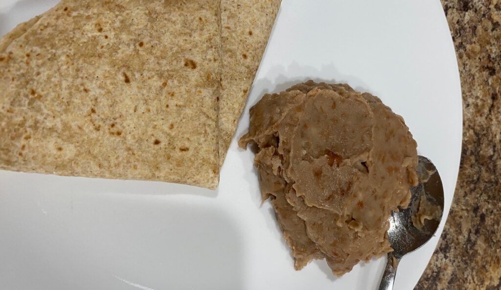 a plate with a tortilla and refried beans