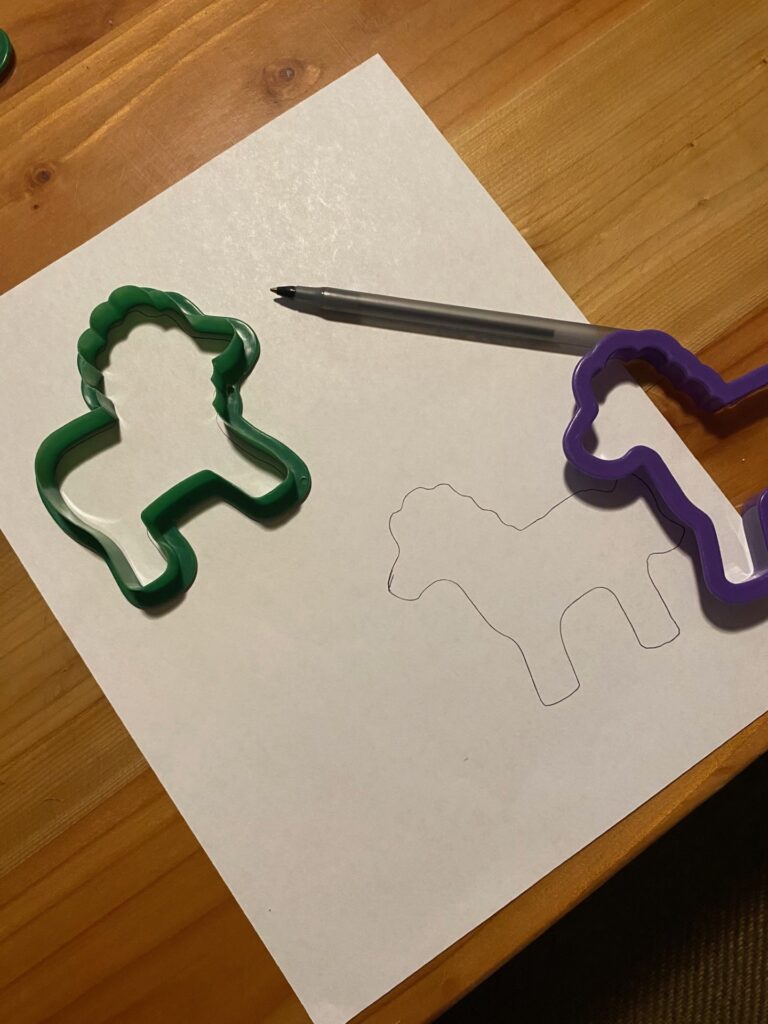 animal shaped cookie cutters being used as stencils with a paper and pen