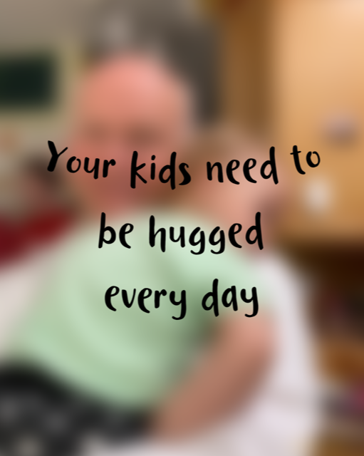 a poster with a blurred man and baby hugging and in front the words "Your kids need to be hugged every day"