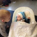 A baby and toddler looking at each other