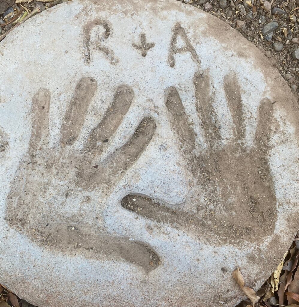 A man's and woman's handprint in cement