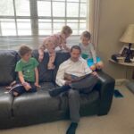 man reading to 3 kids