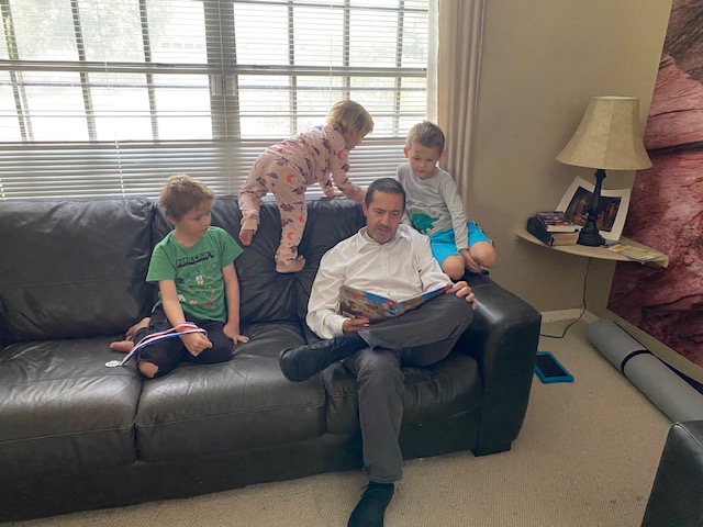 man reading to 3 kids