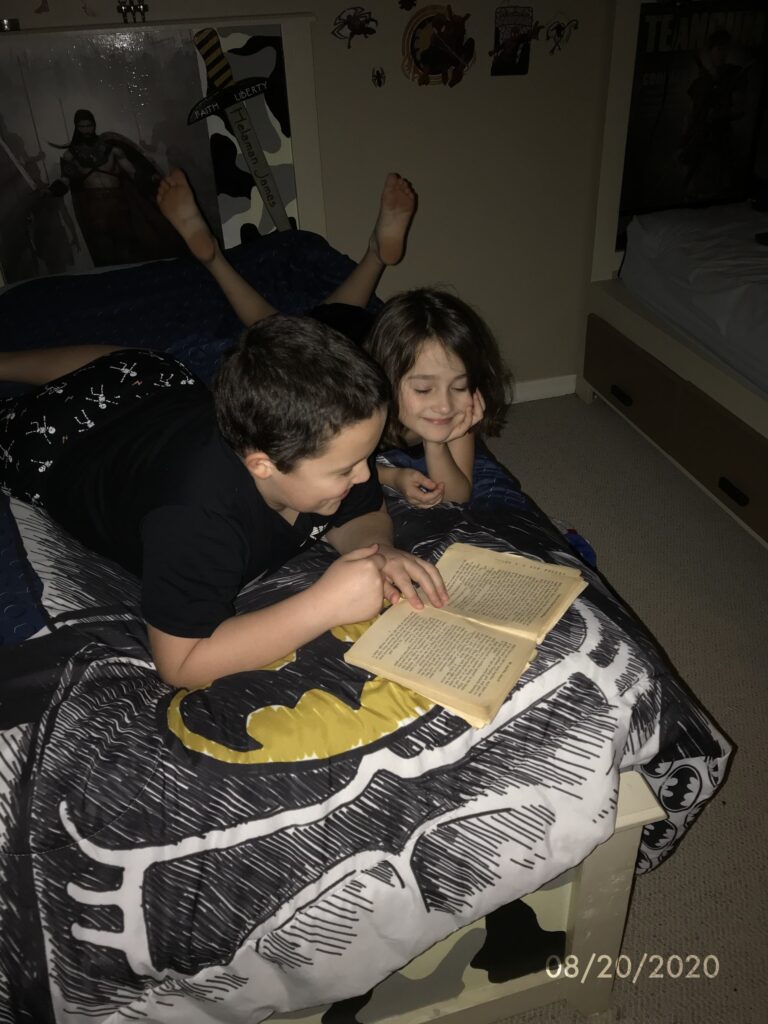 two kids reading a book together