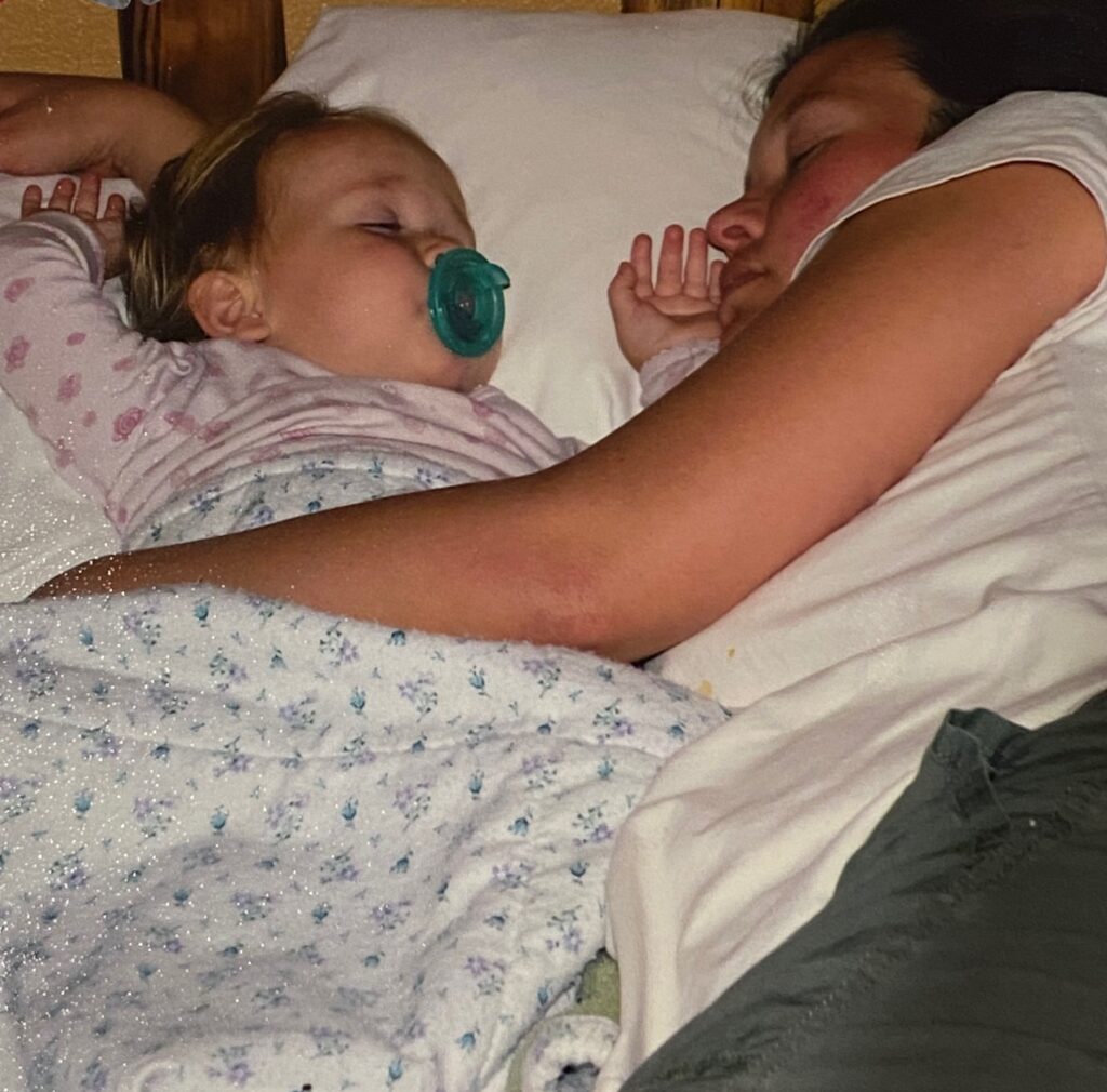 mom and toddler asleep on a bed