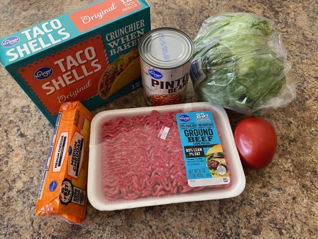 taco shells, ground beef, pinto beans, lettuce, tomato, and cheese